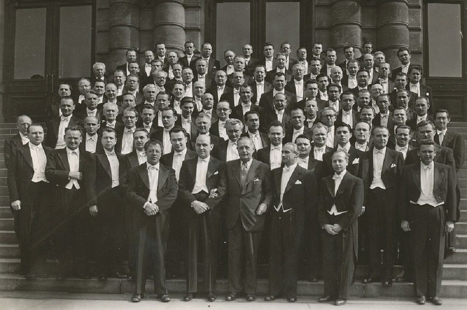 Skupinová fotografie České filharmonie na schodech Rudolfina (1954). Karel Ančerl v dolní řadě